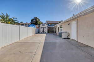 Fenced backyard featuring a storage shed