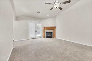 Unfurnished living room with carpet flooring, a tiled fireplace, a ceiling fan, and recessed lighting
