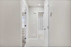 Hallway with light tile patterned flooring and baseboards