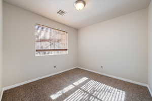 Unfurnished room featuring carpet flooring and a textured ceiling