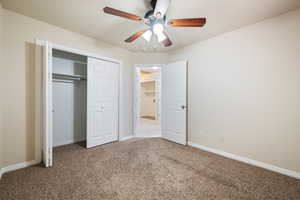 Unfurnished bedroom featuring carpet floors, ceiling fan, and a closet