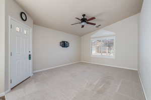 Spare room with light colored carpet, a ceiling fan, and lofted ceiling
