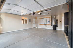 Garage featuring water heater, electric panel, and a garage door opener