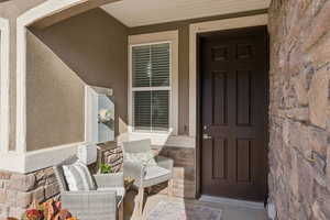 Doorway to property with stone siding and stucco siding