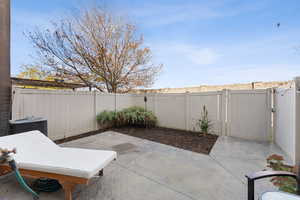 Fenced backyard featuring a patio area and a gate