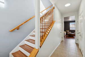 Stairway featuring tile patterned flooring and baseboards