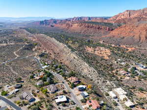 Aerial view of property and surrounding area with a mountain backdrop and nearby suburban area