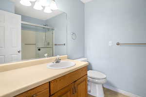Full bath with vanity, a stall shower, tile patterned floors, and a chandelier