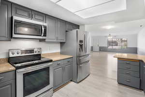 Kitchen featuring gray cabinetry and appliances with stainless steel finishes