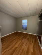 Unfurnished bedroom featuring light wood-type flooring, a closet, and vaulted ceiling