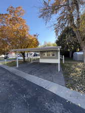 View of front of house with asphalt driveway and a carport