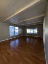 Unfurnished room featuring beam ceiling and light wood-style flooring