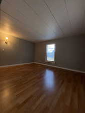 Unfurnished room with light wood finished floors and a decorative wall