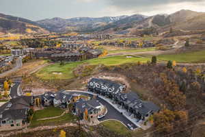 Aerial view of property's location featuring nearby suburban area, a golf club, and mountains