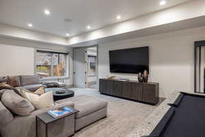 Carpeted living area featuring recessed lighting and baseboards