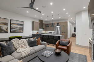 Living room with light wood-style flooring, recessed lighting, and ceiling fan