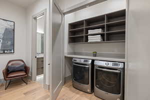 Washroom featuring light wood finished floors and independent washer and dryer