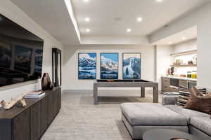 Living room featuring light colored carpet, recessed lighting, and a tray ceiling