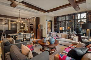 Living room featuring coffered ceiling, beam ceiling, wood finished floors, and a chandelier