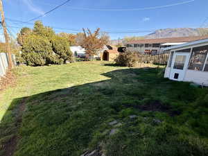 View of yard featuring a storage shed and a sunroom