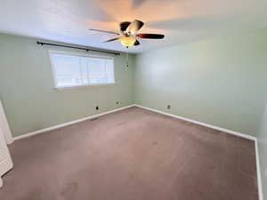 Unfurnished room featuring carpet floors, a ceiling fan, and a textured ceiling