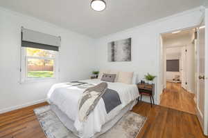 Bedroom featuring ornamental molding and dark wood-style floors