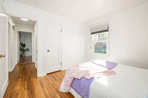Bedroom featuring hardwood / wood-style floors and crown molding