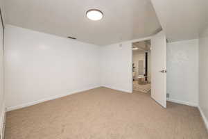 Unfurnished bedroom featuring light colored carpet and baseboards