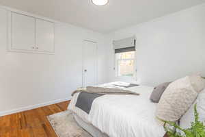 Bedroom featuring wood finished floors and ornamental molding