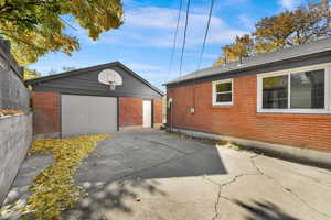 Back of home with large patio and access to the garage.