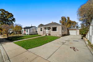 Bungalow-style home featuring an outbuilding, driveway, and a detached garage