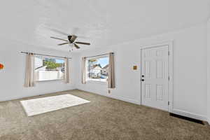 Carpeted entrance foyer featuring  a ceiling fan
