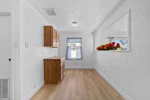 Unfurnished dining area featuring light wood-style flooring and a textured ceiling
