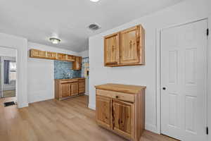 Kitchen featuring decorative backsplash, butcher block counters, and light wood-style floors