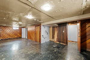 Below grade area featuring wood walls and dark flooring