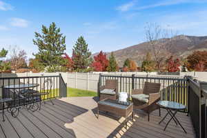 Deck with a fenced backyard, a mountain view, and outdoor dining area