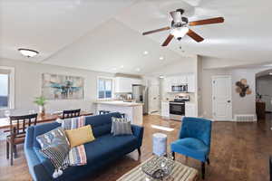 Living room featuring vaulted ceiling, light wood-style floors, a ceiling fan, arched walkways, and recessed lighting