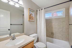 Bathroom featuring shower / bathtub combination with curtain and vanity