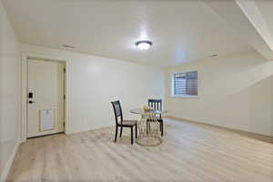 Dining area featuring light wood-type flooring and a textured ceiling