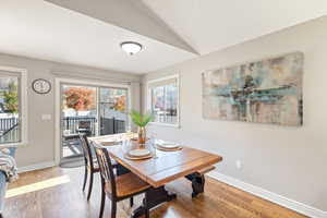 Dining area with wood finished floors and vaulted ceiling
