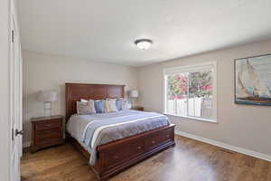 Bedroom featuring wood finished floors and a textured ceiling