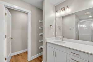 Bathroom with vanity, light wood-style flooring, and a stall shower