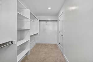 Walk in closet with light carpet