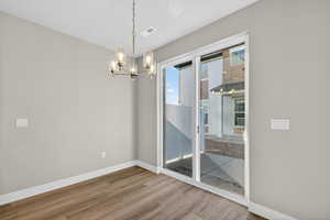 Unfurnished dining area featuring light wood-type flooring and a chandelier