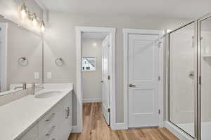 Full bath featuring a shower stall, light wood-style floors, vanity, and a textured ceiling