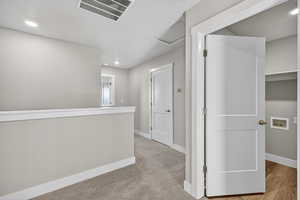 Hall with recessed lighting, light carpet, and attic access