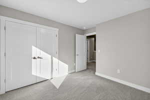 Unfurnished bedroom with carpet and a closet