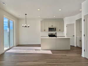 Kitchen featuring a center island with sink, recessed lighting, stainless steel appliances, and dark wood finished floors