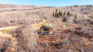 Aerial view of property and surrounding area featuring a forest