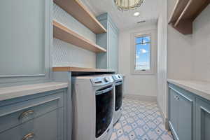 Laundry area with washer and clothes dryer, recessed lighting, a chandelier, and cabinet space